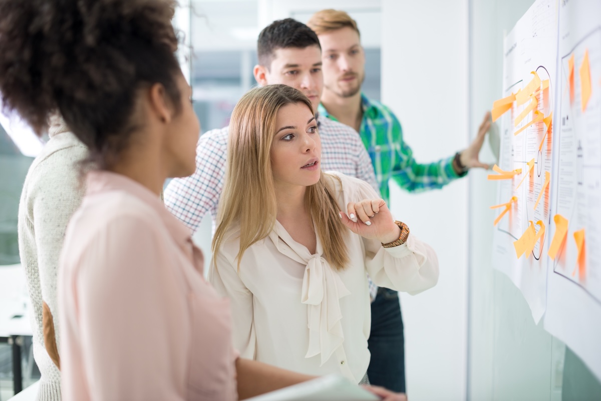 Staff reviewing a white board